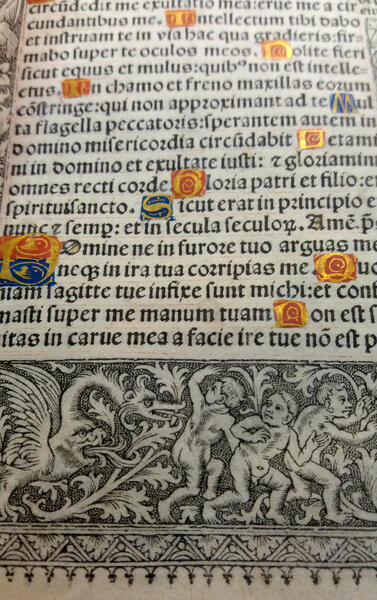 Detall de l’orla inferior amb motius grotescos on es poden copsar els efectes de la tècnica del criblé.  Noti’s també les caplletres miniades de les caplletres i les restes de les pautes de text. (recto del f. ms. 18)